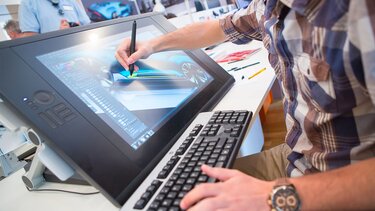 Mann arbeitet am Design eines Renault Fahrzeugs an seinem Rechner