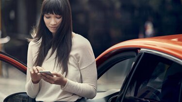 Frau verbindet sich am Handy mit dem Renault Connect System